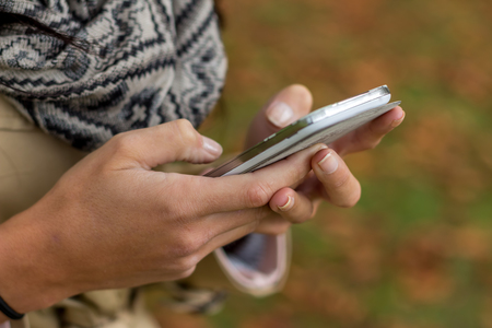 Eine junge Frau schreibt auf seinem Handy ein SMS. Kommunikation mit einem Smart phone